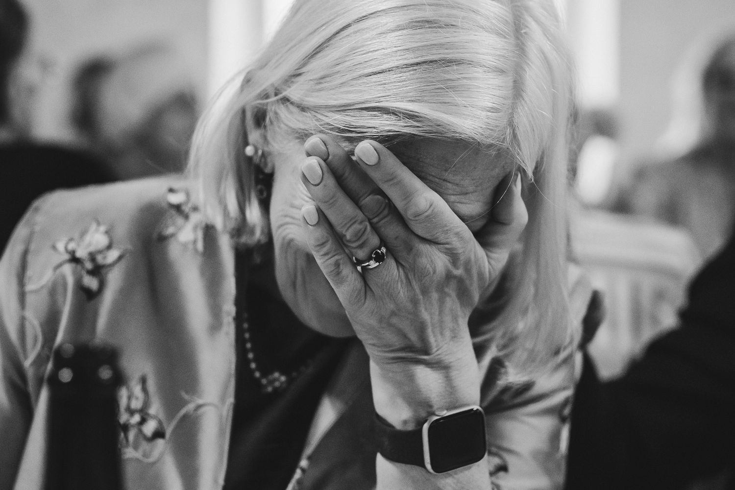 A collage of black and white photos showing people reacting emotionally while attending an event.