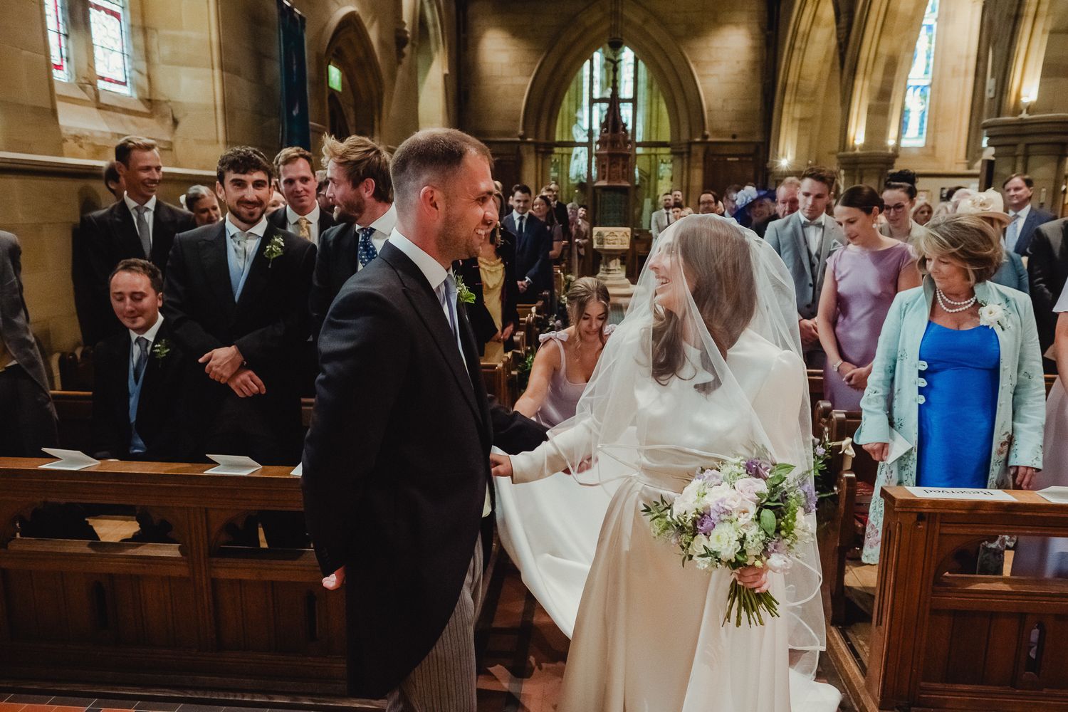 Bride and groom share a joyful moment during their traditional church wedding ceremony.