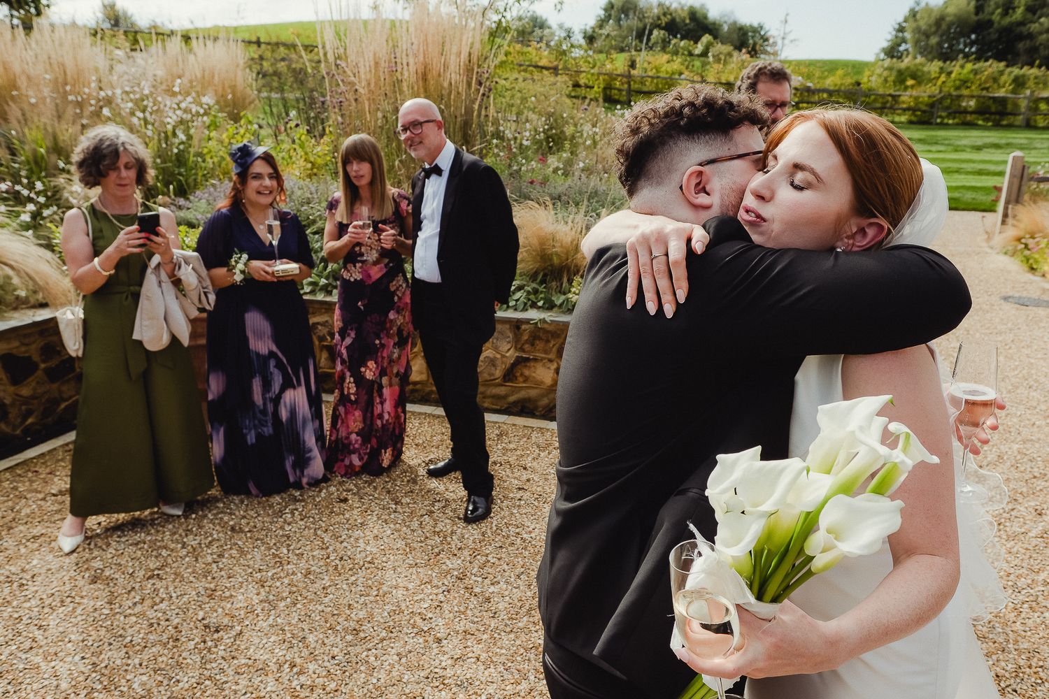 Wedding guests enjoy champagne toasts during an outdoor garden celebration.