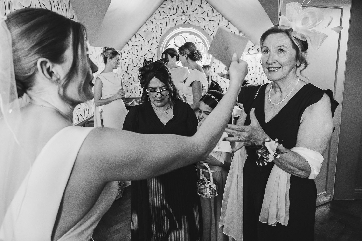 A series of black and white wedding photos showing guests dancing and celebrating at a reception party.