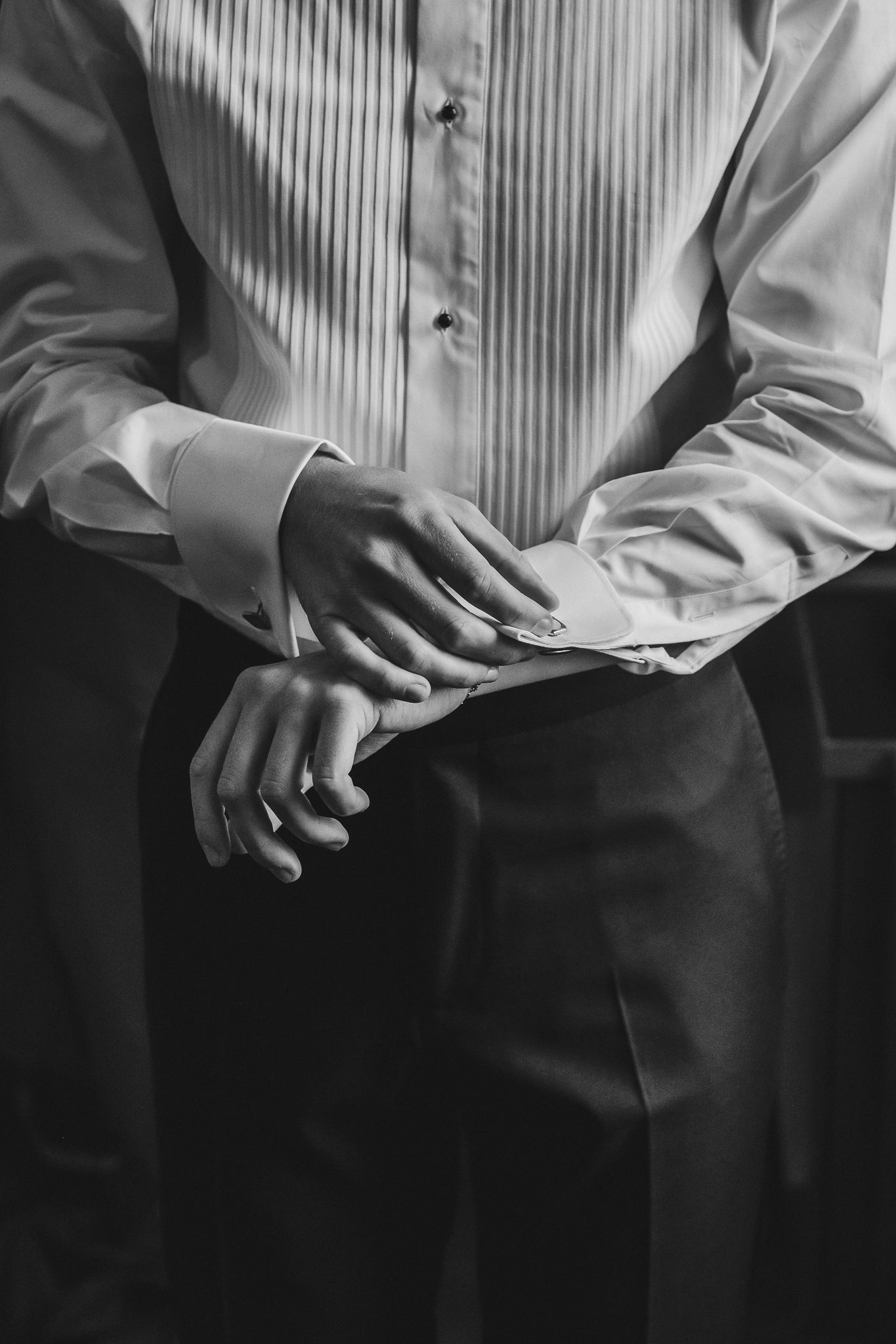 Black and white series of cropped photos showing hands clasped together against a striped background.