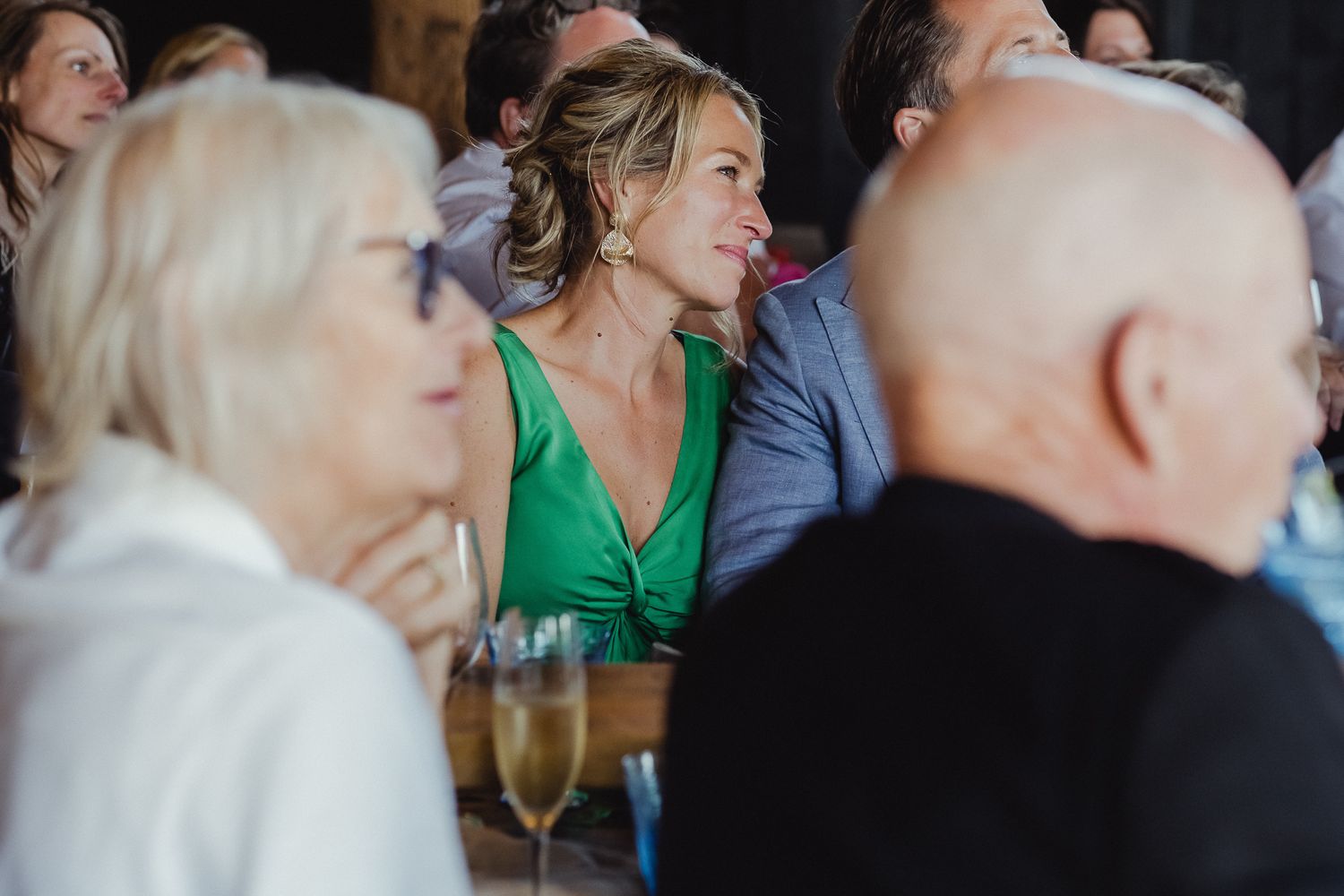 A group of people engaged in animated conversation during a social gathering or dinner party.