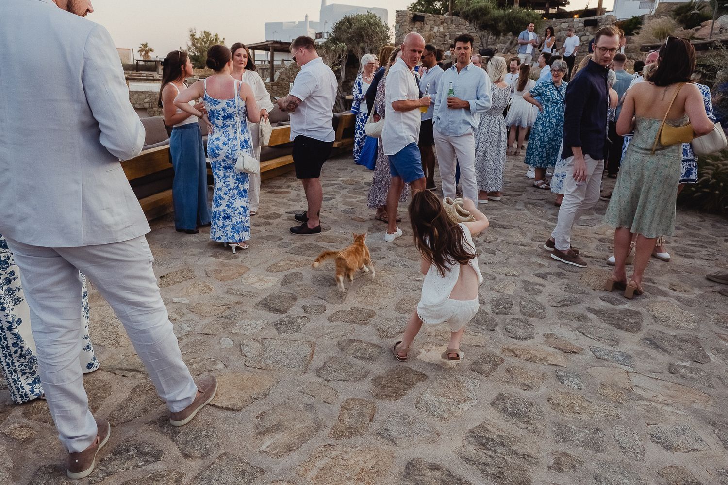 Tourists gather on a sandy beach during sunset to watch the evening activities and entertainment.
