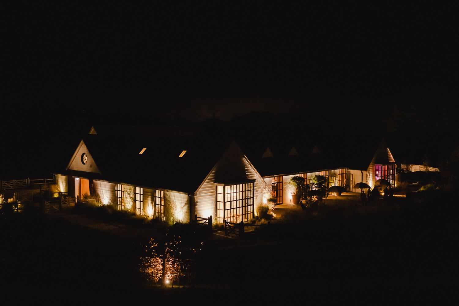 A row of illuminated homes glows warmly against the dark night sky creating a cozy residential scene.