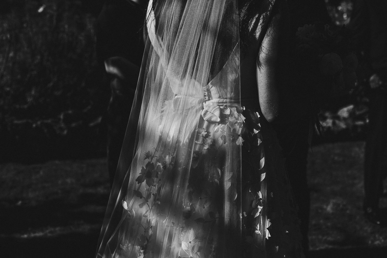 Artistic black and white detail shot of a wedding veil in natural light.