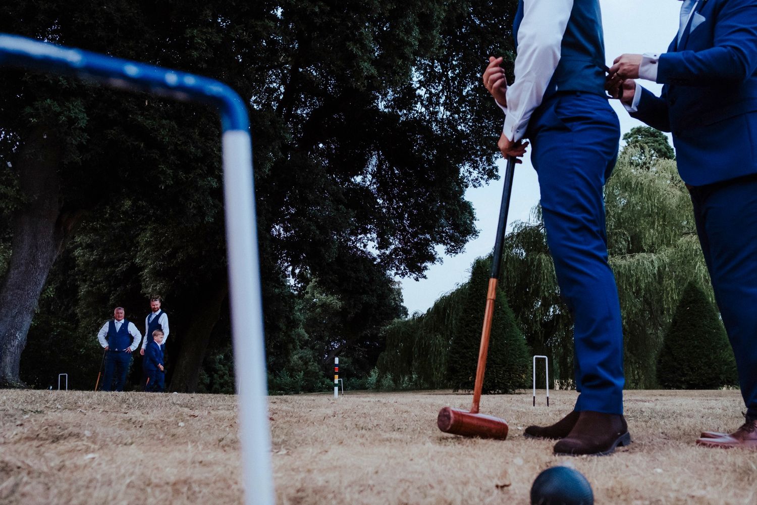 Close-up of croquet mallet and wicket during outdoor wedding game.