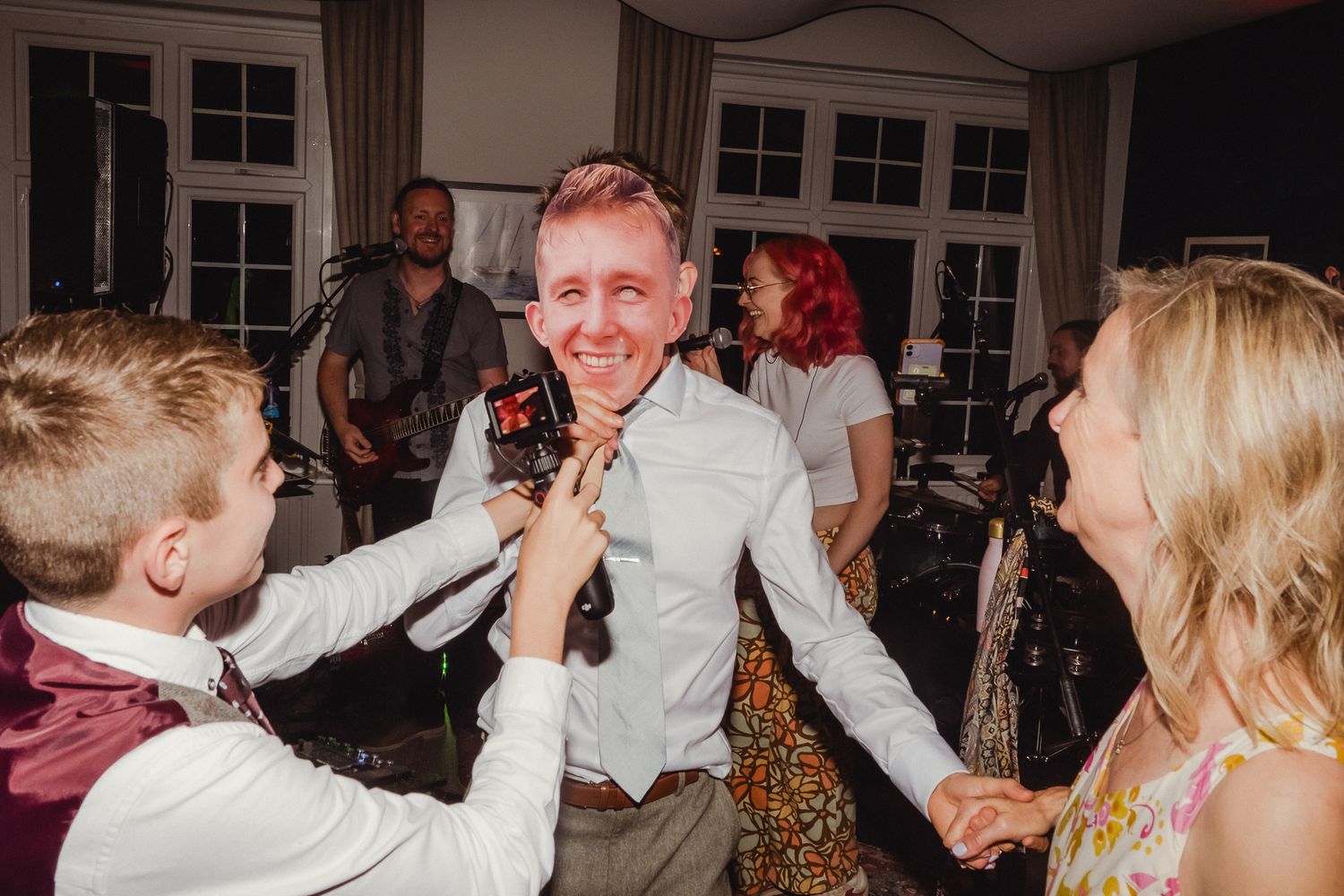 People dancing and celebrating together at a lively indoor party or reception venue.