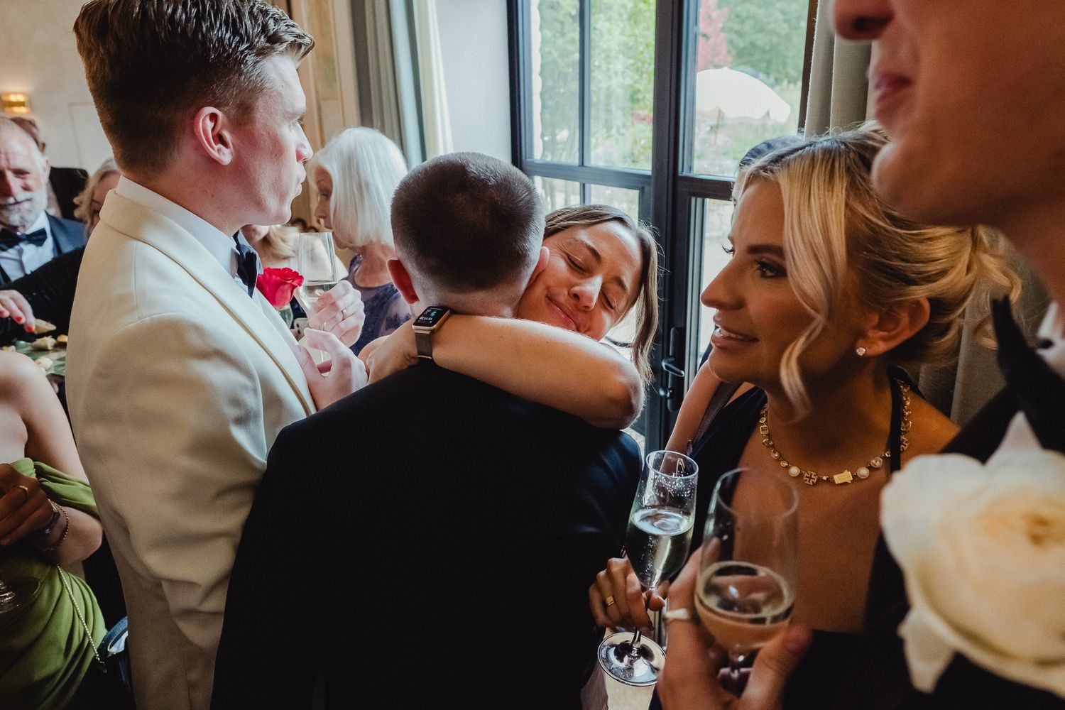 Wedding guests mingle and socialize during an indoor reception celebration at an elegant venue.