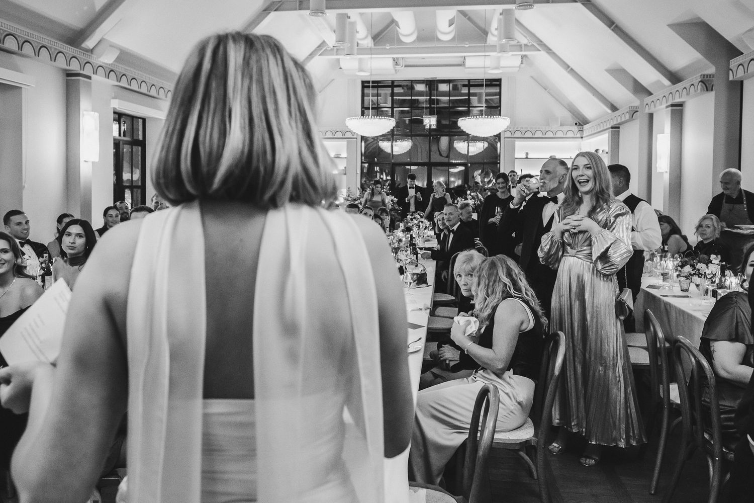 A series of black and white wedding photos showing a reception celebration with guests dancing and mingling.