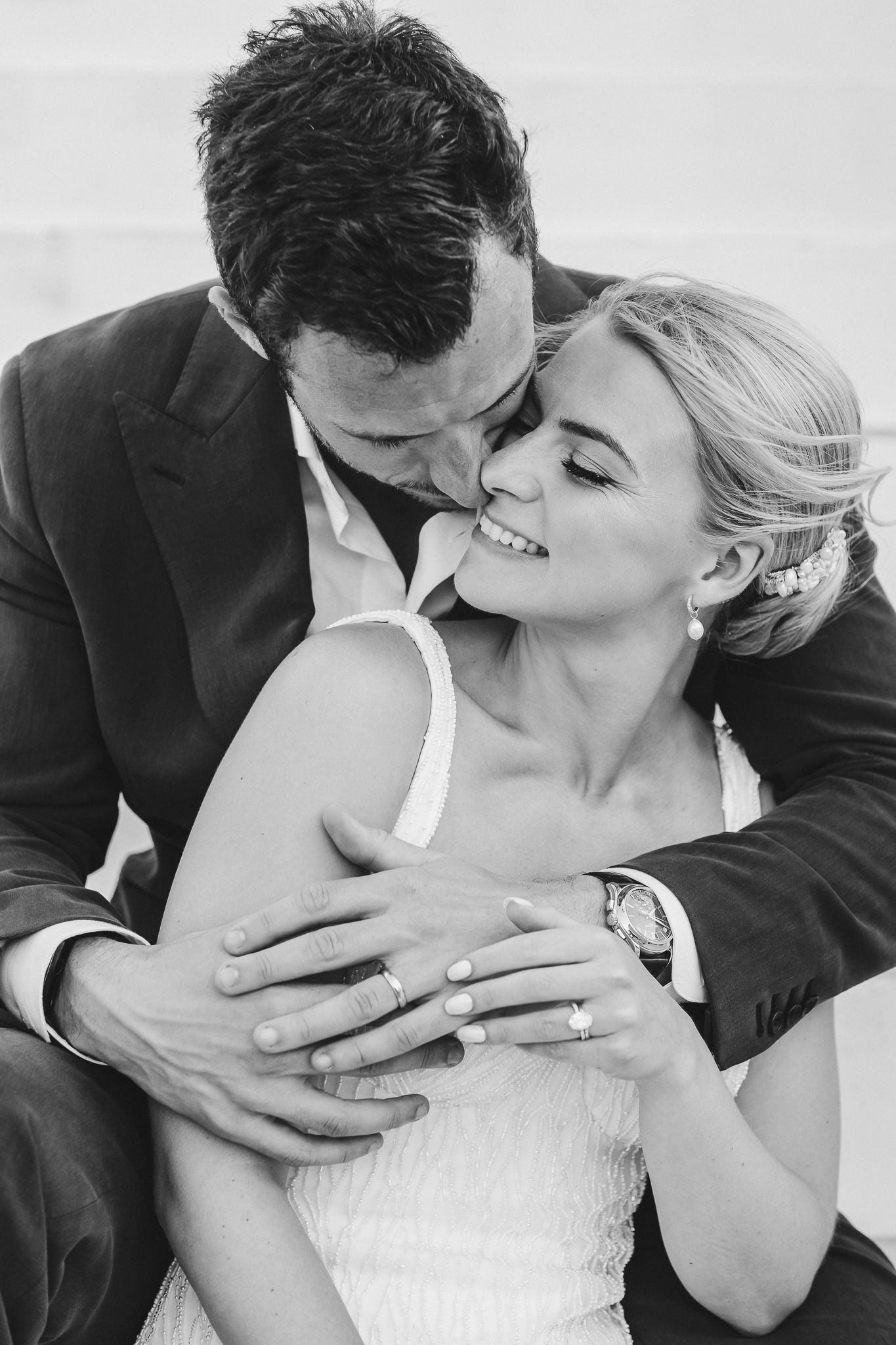 A romantic sequence of black and white wedding photos showing tender kissing moments between newlyweds.