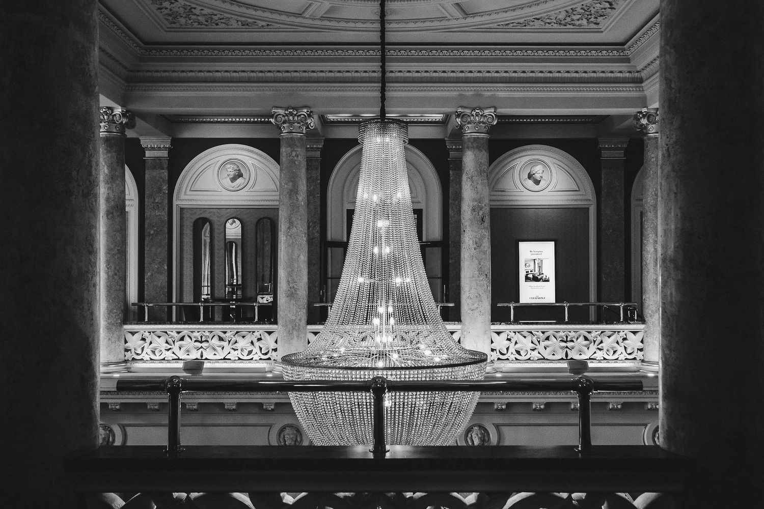 Ornate theater interior with classical architectural details and crystal chandeliers illuminating the grand space.