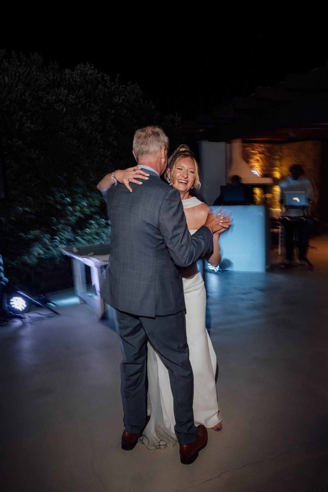 Bride and groom share a romantic first dance outdoors at night during their wedding reception.