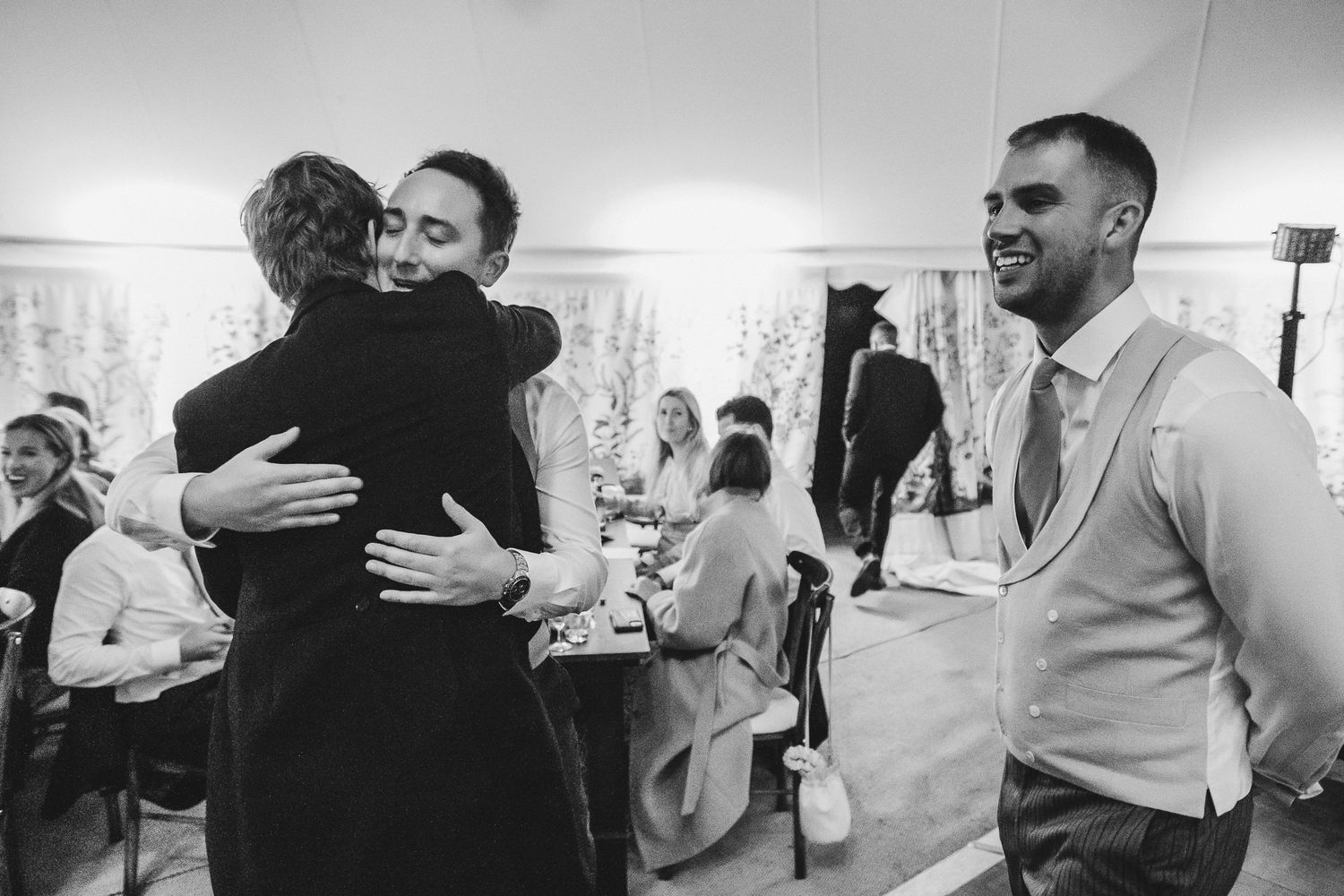 Black and white photos show healthcare workers embracing and supporting each other in an emotional moment at a medical facility.