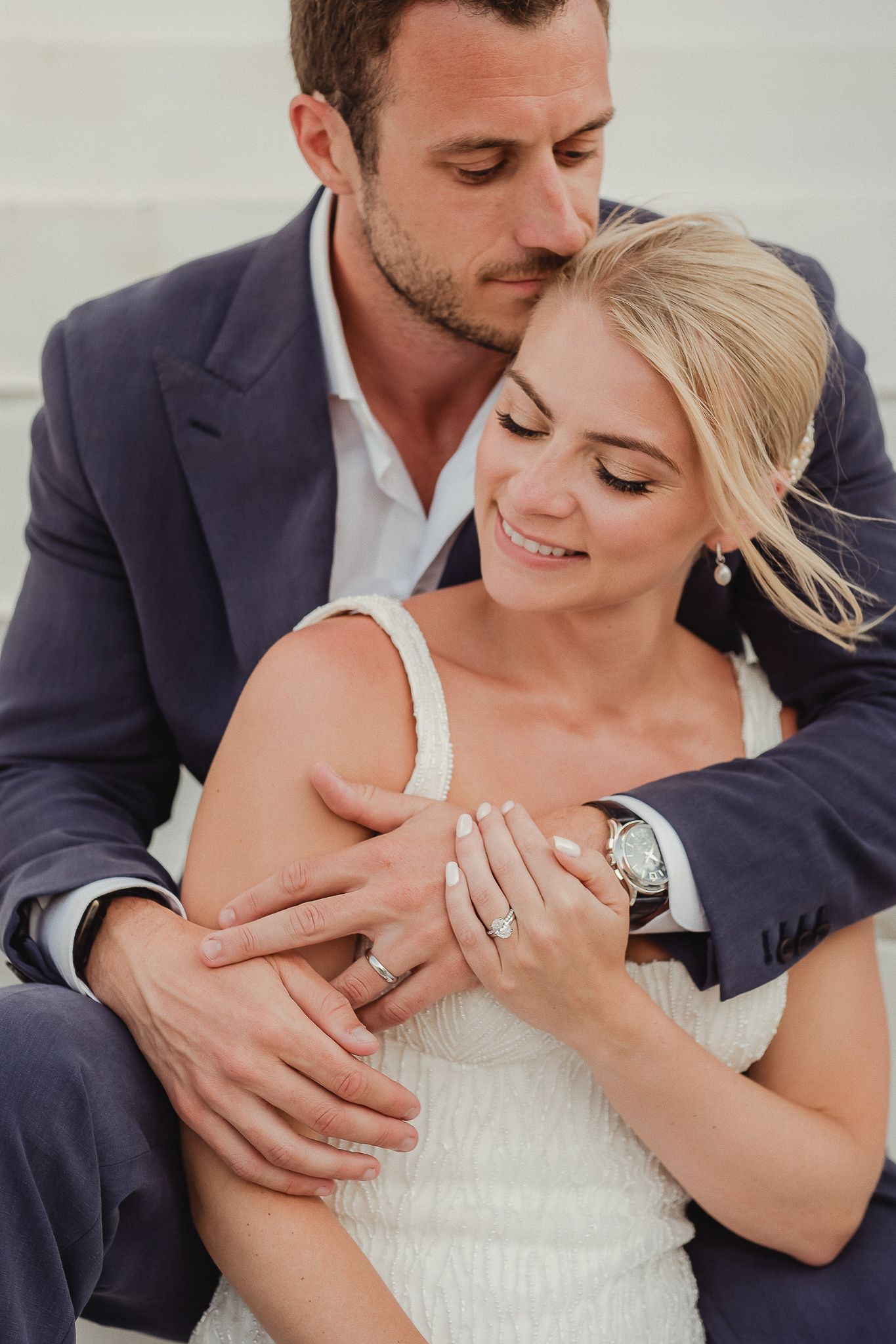 Close-up detail shots show a bride and groom embracing while displaying an elegant diamond engagement ring.