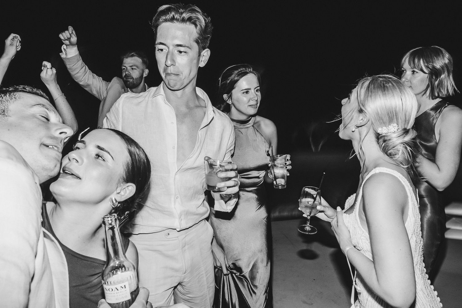 A black and white photo series shows revelers dancing and enjoying themselves at what appears to be a party or club.