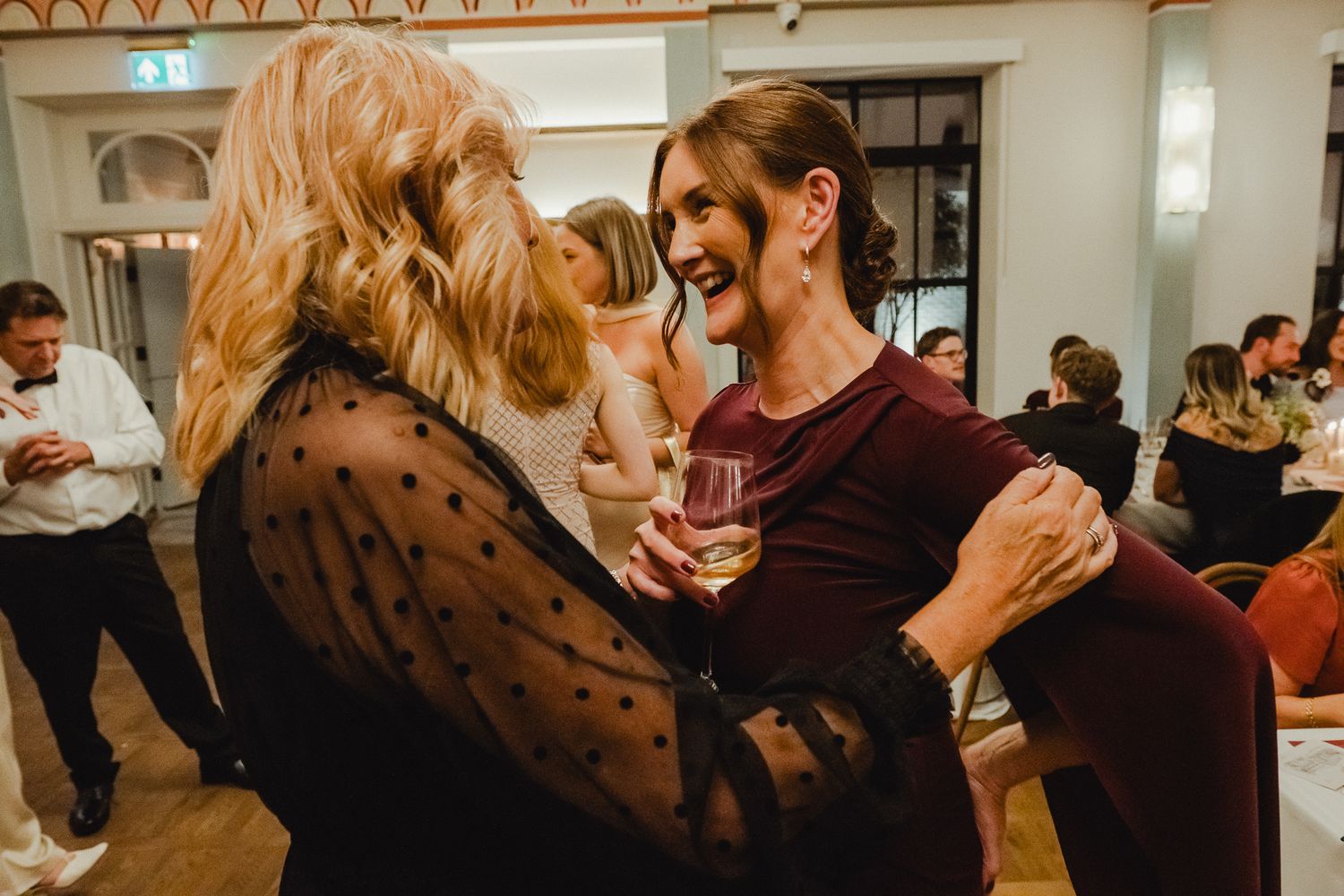 Couples dance together in a ballroom during a social dance class or event.