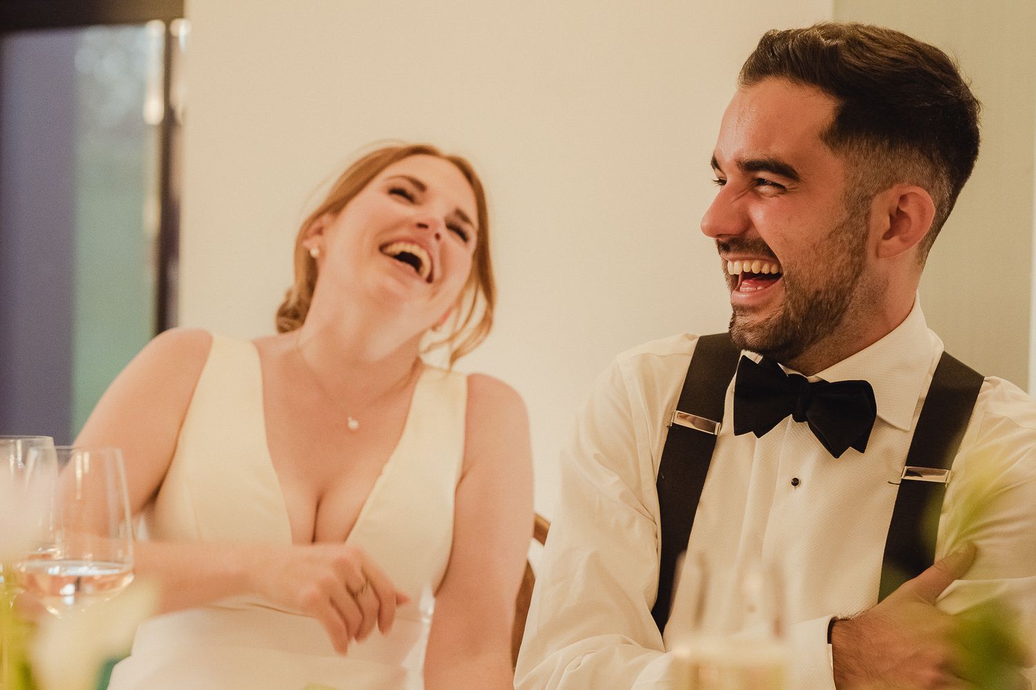 Candid moments of laughter and joy captured between a couple during their wedding celebration.