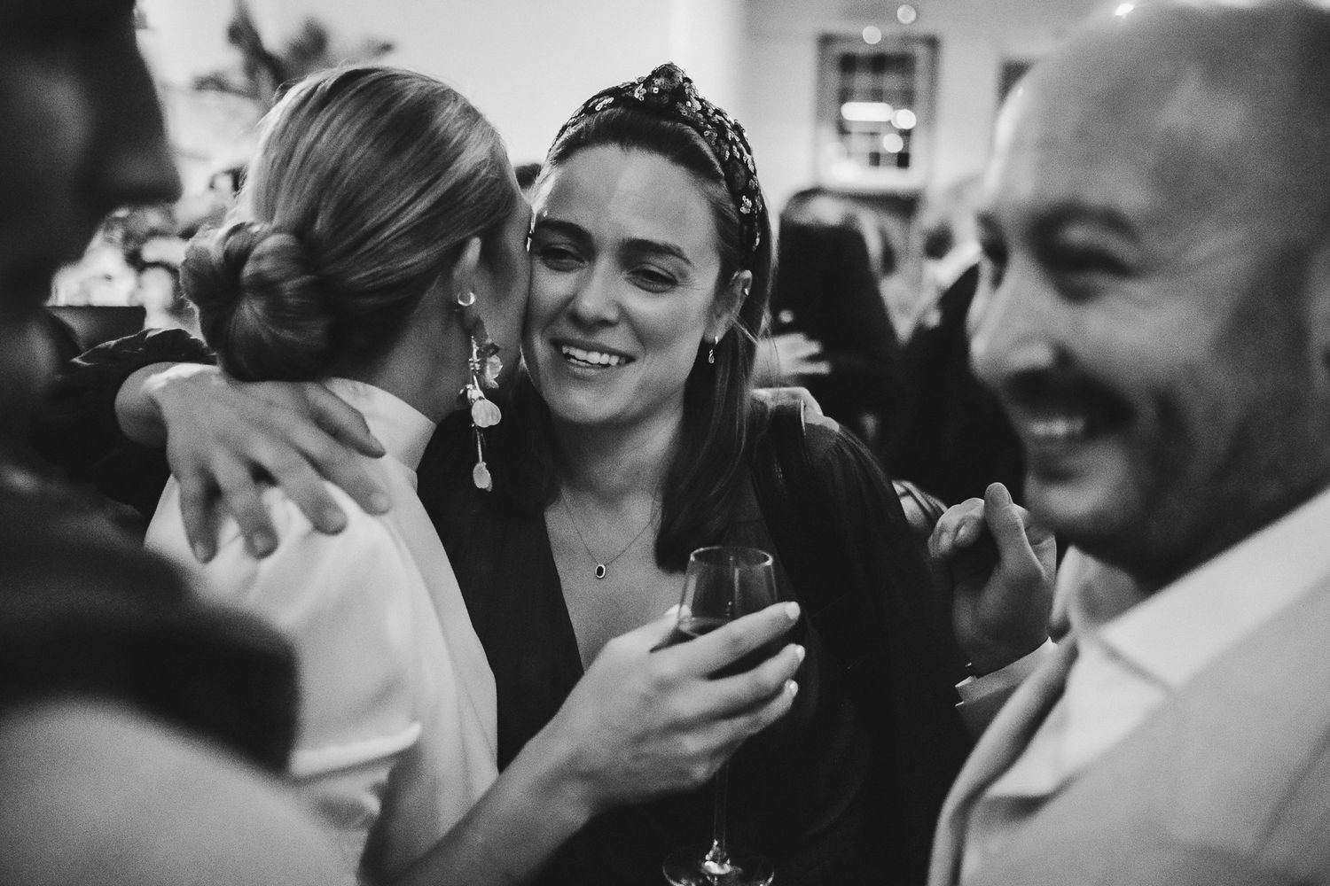 A series of black and white candid wedding photos capturing intimate emotional moments between guests and newlyweds.