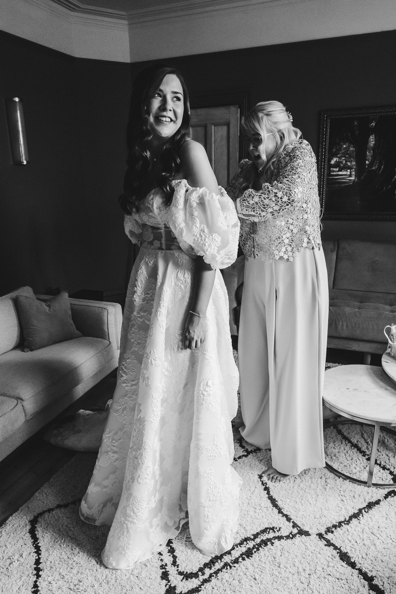 A series of black and white photos showing someone in a flowing white wedding dress or gown against a carpeted floor.
