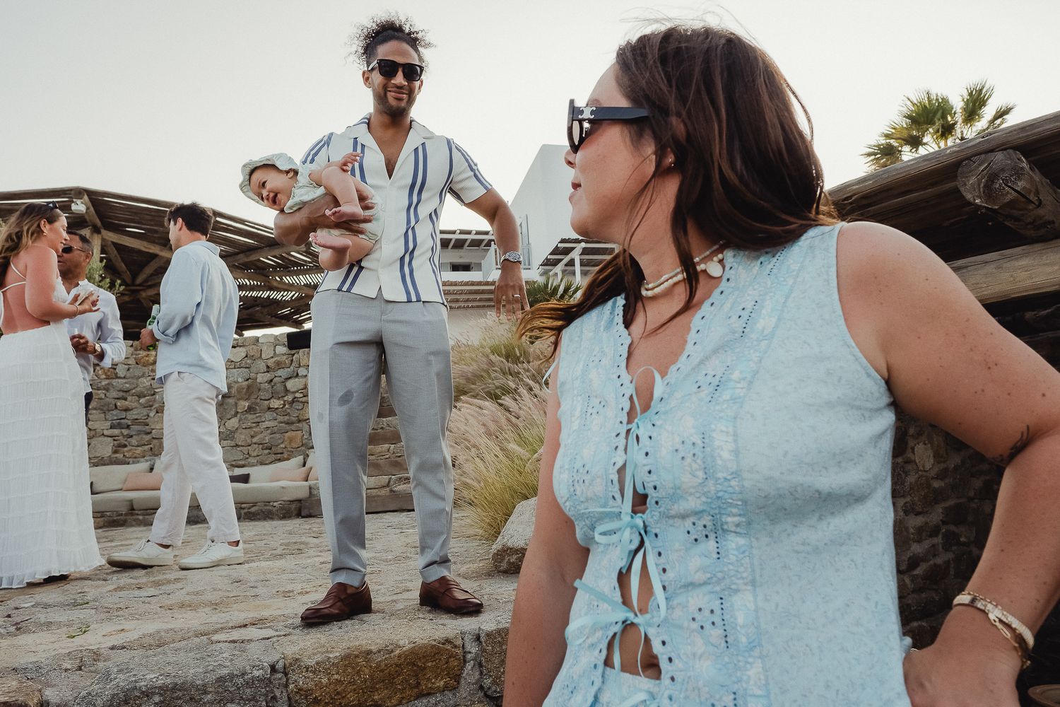 People enjoying themselves at an outdoor summer event wearing light denim and white outfits in a festive setting.
