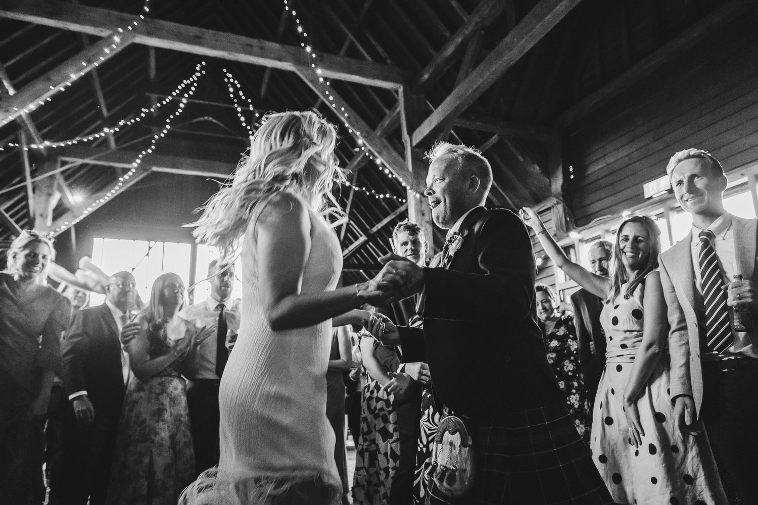 A black and white photo montage shows people dancing and celebrating at a lively wedding reception party.