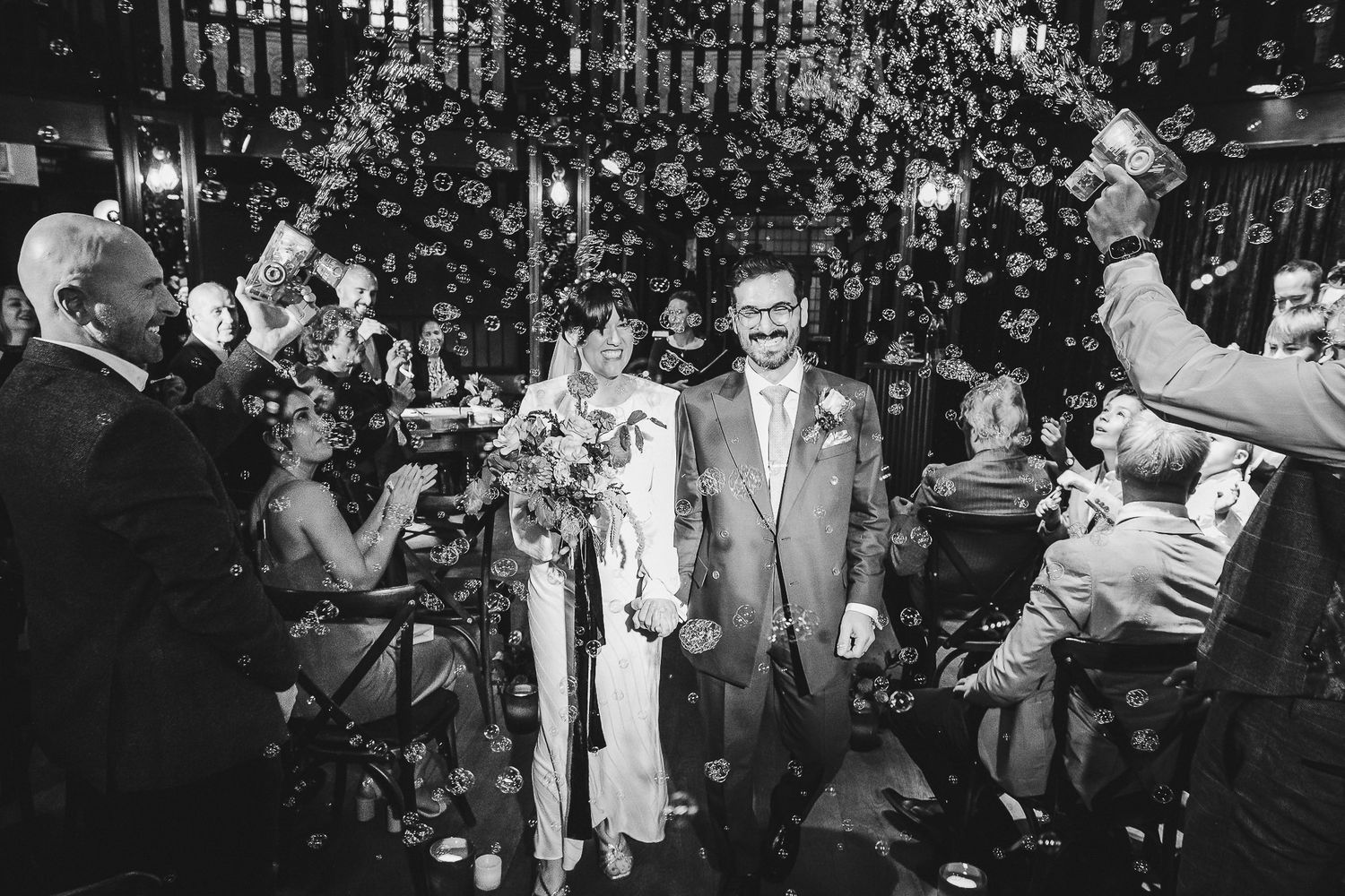 Wedding guests celebrate and dance together at an outdoor reception during a joyful moment.