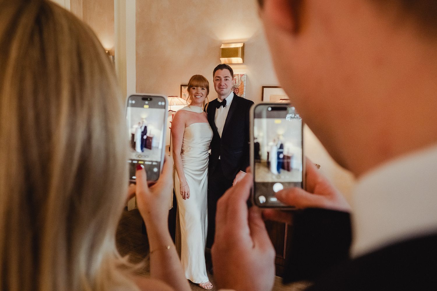 Candid moments captured between guests during a celebration in a warmly lit indoor space.