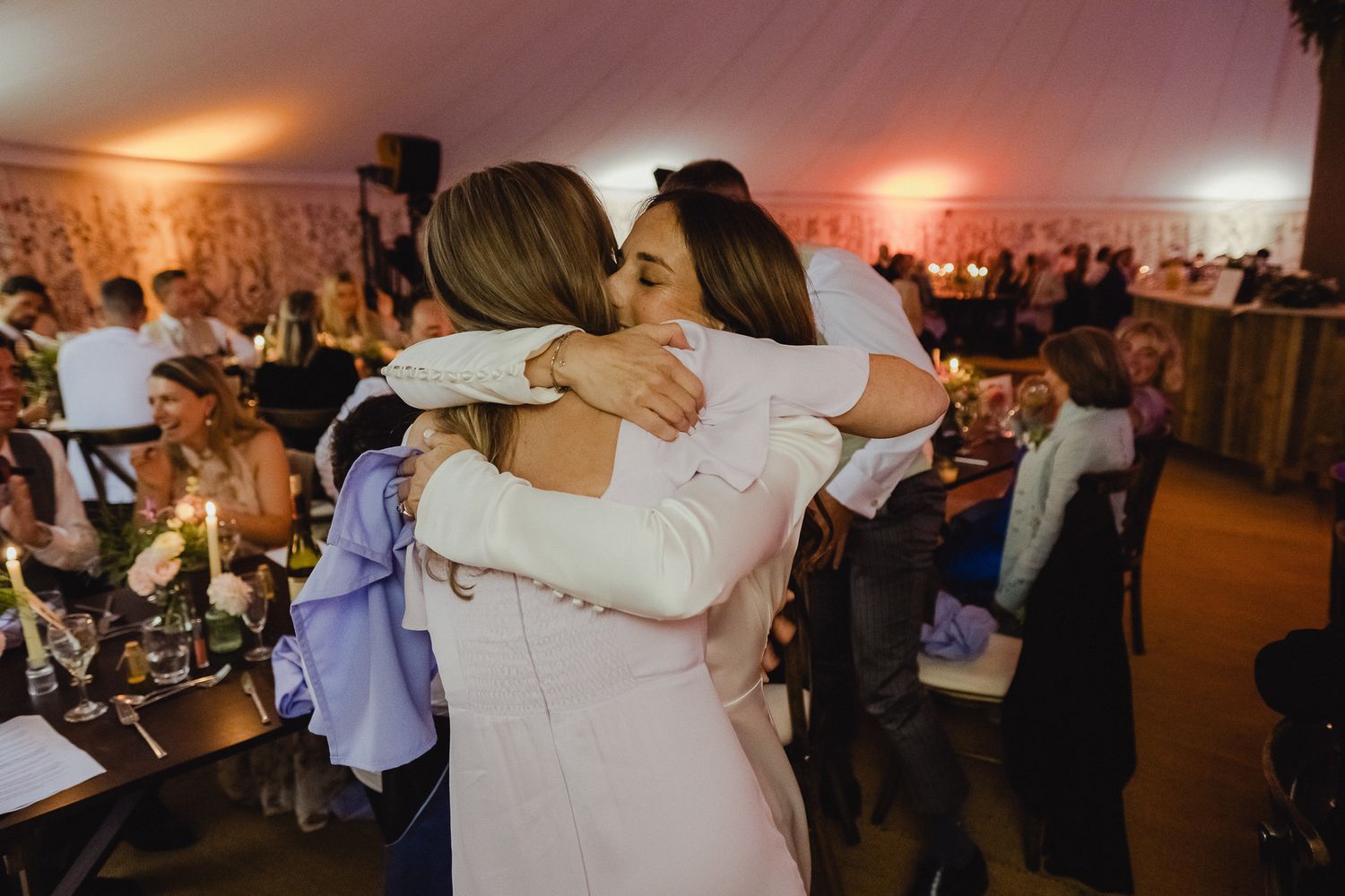 Couples dance together at an evening wedding reception in a warmly lit venue.