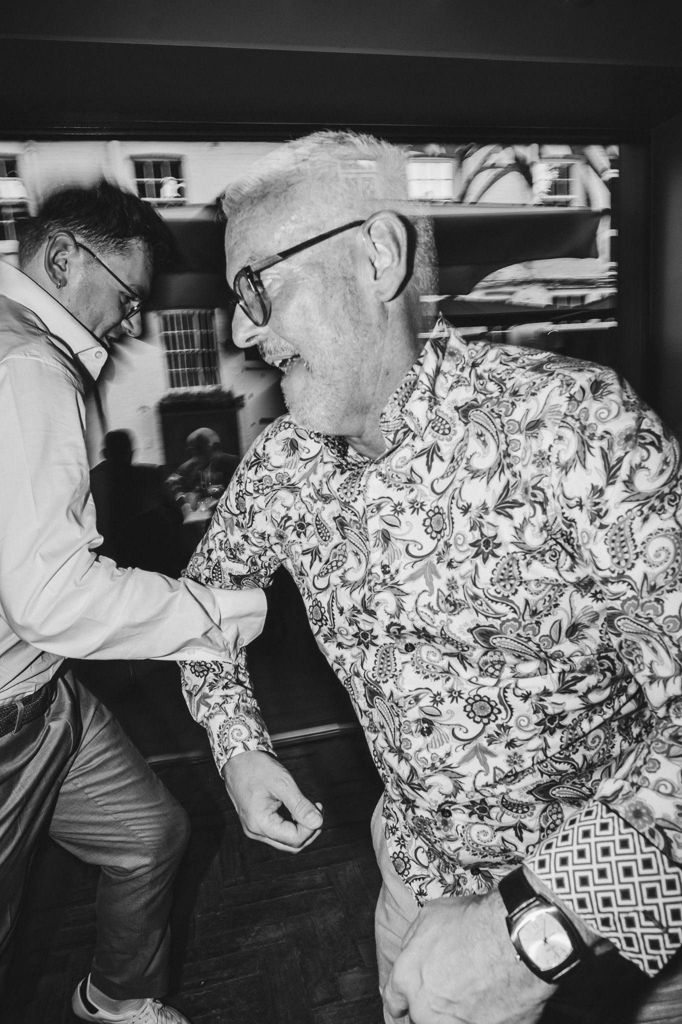 A sequence of black and white photos showing someone wearing a floral patterned shirt dancing in an office setting.