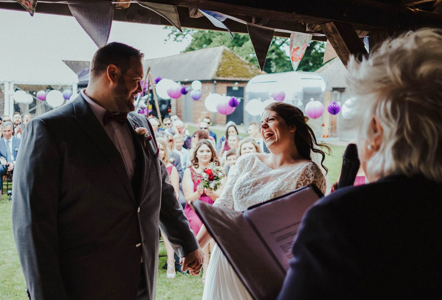 Wedding guests watching the celebrations under a decorated outdoor tent.