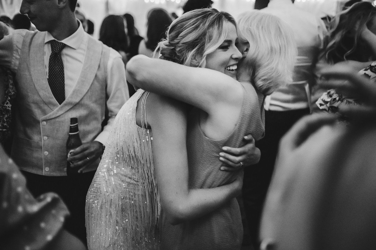 Two guests sharing an emotional embrace during a wedding celebration.