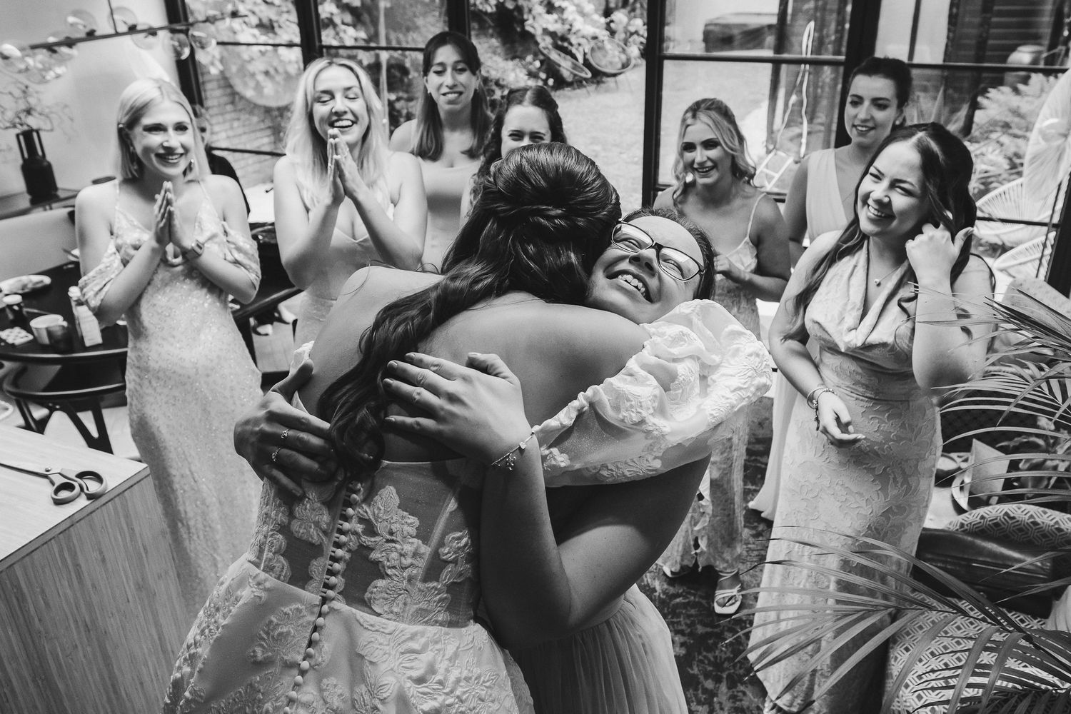 A joyful wedding celebration with people dancing and laughing together at a reception party.