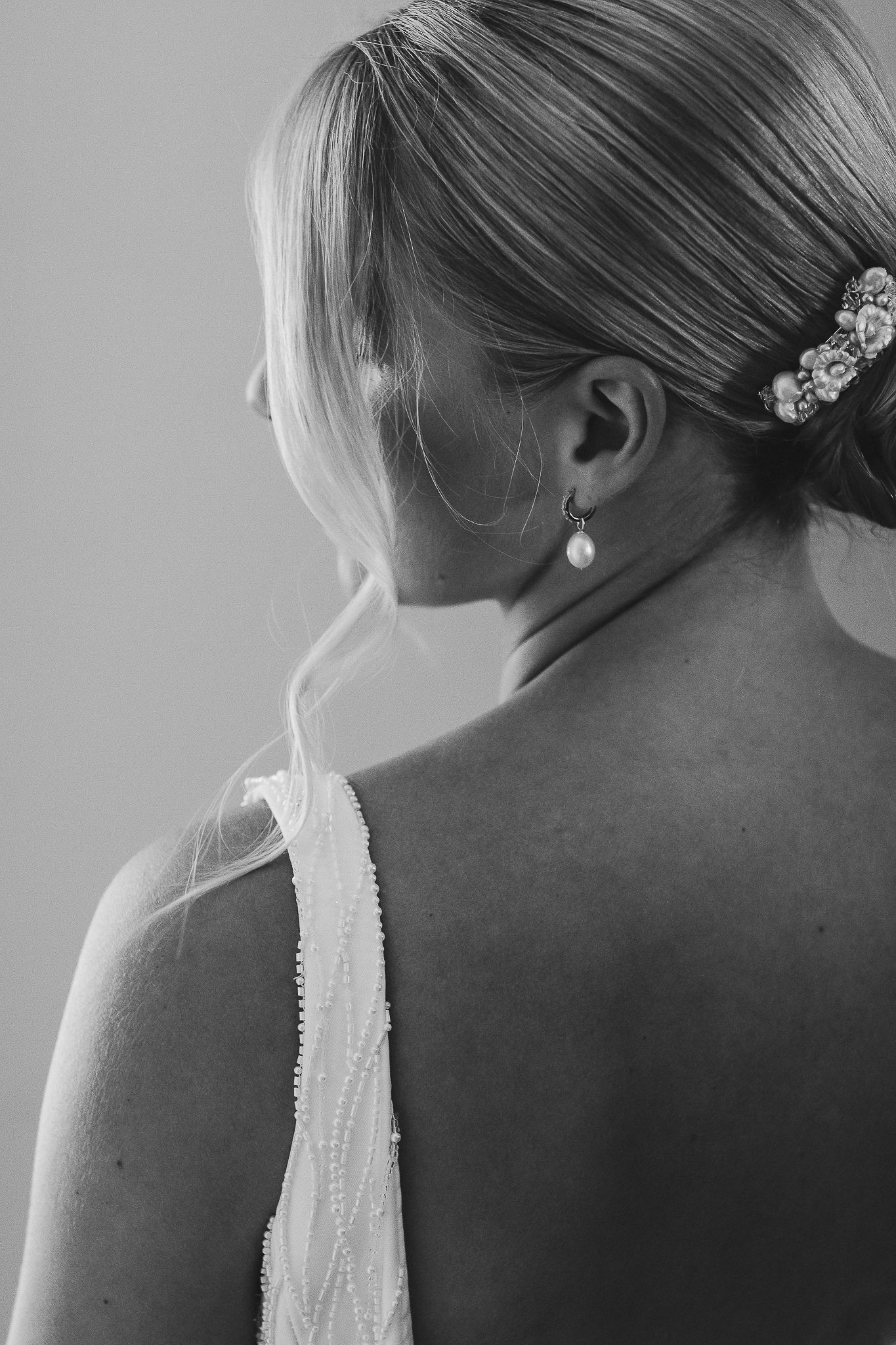 Elegant black and white portraits highlighting delicate pearl earrings and hair accessories against a light background.