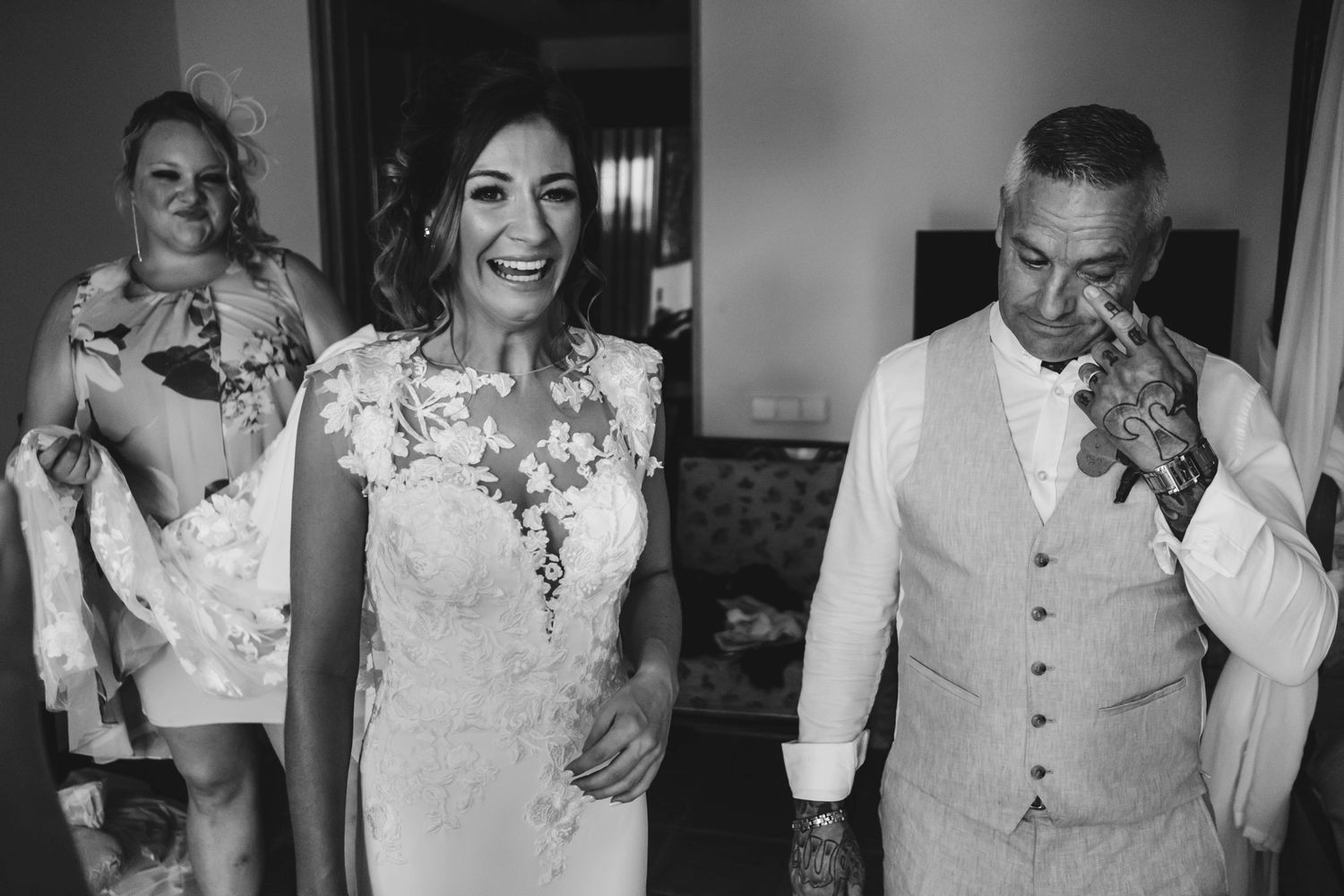 Black and white candid shot of wedding party sharing a joyful moment.