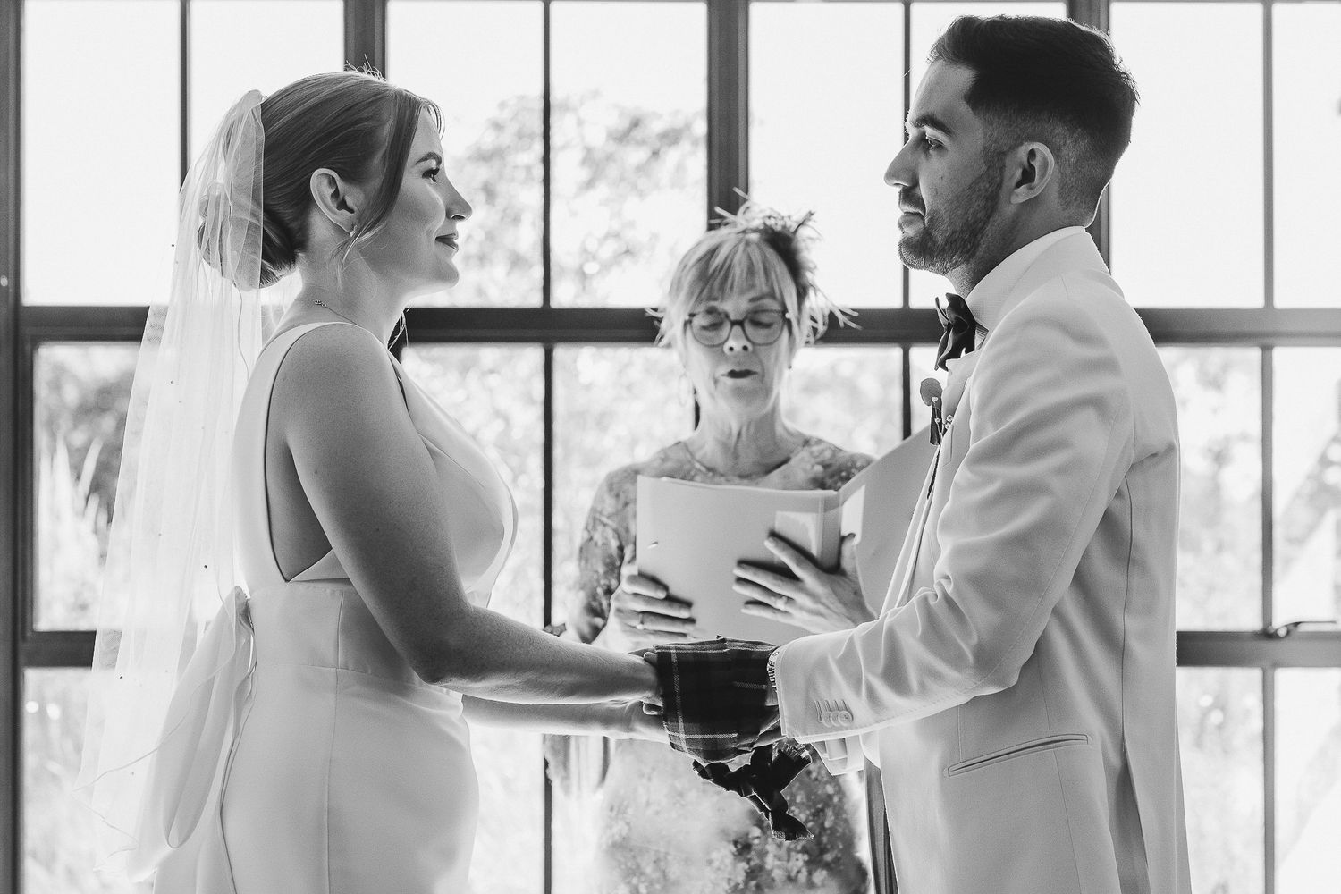 A series of black and white wedding moments showing couples dancing and embracing during a celebration.
