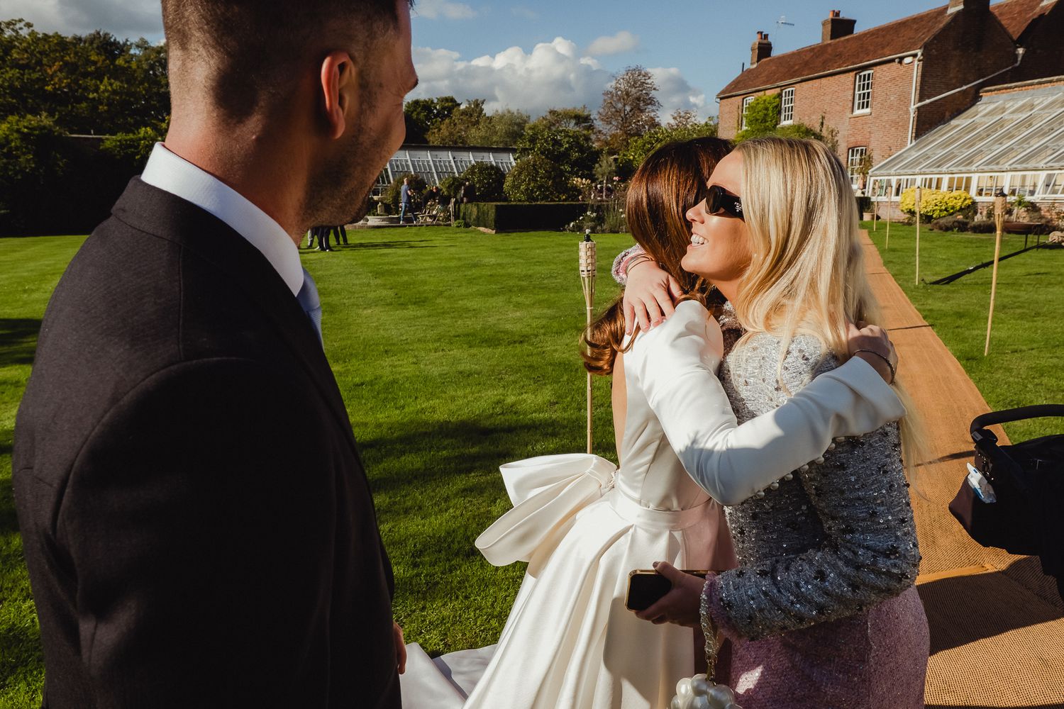A couple shares a romantic kiss during their outdoor wedding ceremony at a scenic countryside venue.