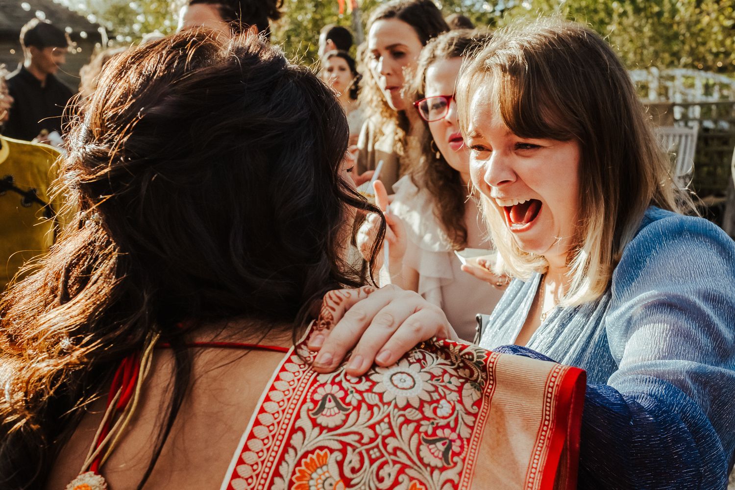 Candid moment of celebration and laughter at a fusion wedding reception.