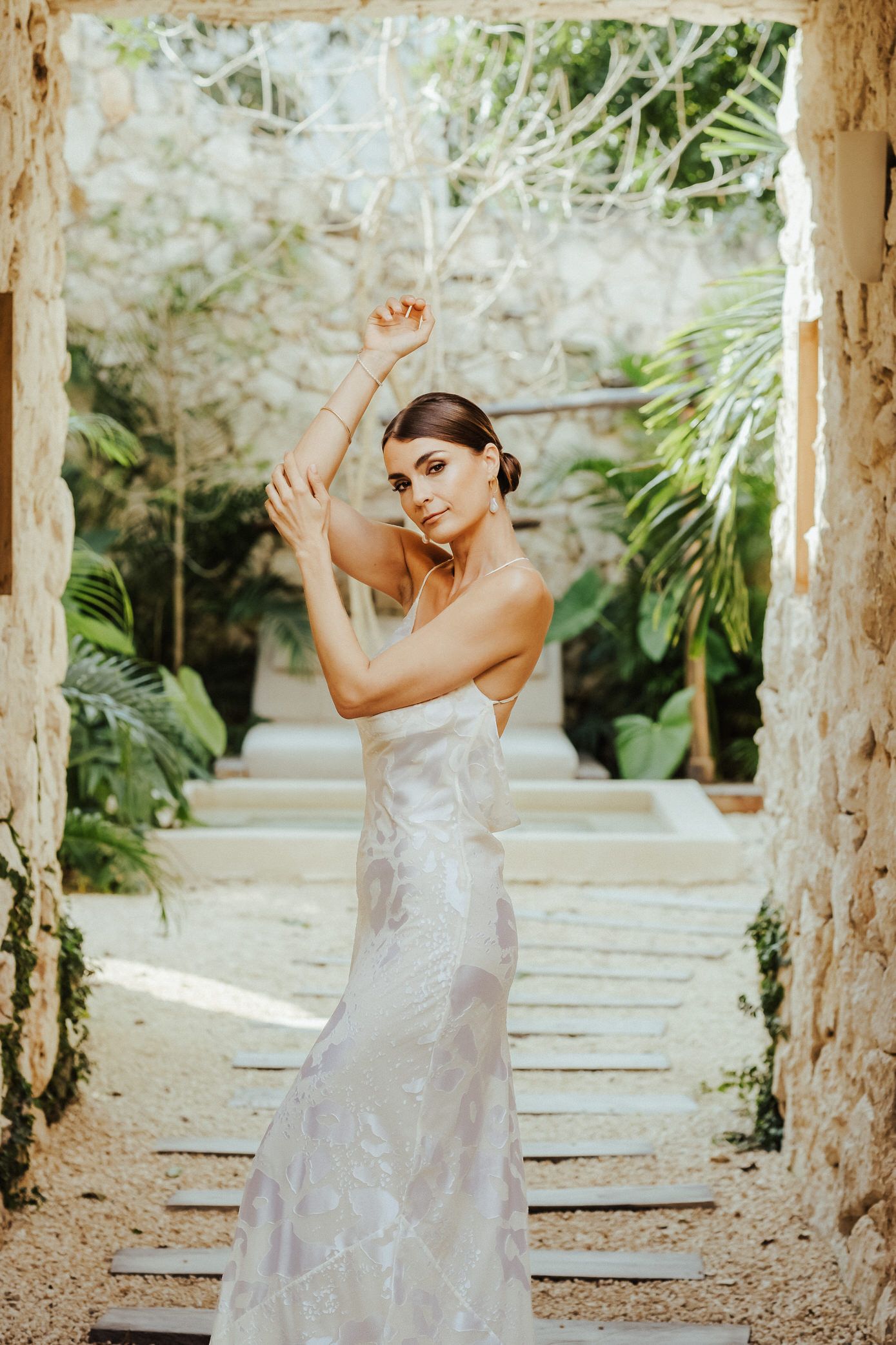 A sequence of artistic dance movements captured in a sunlit garden pergola with stone columns.