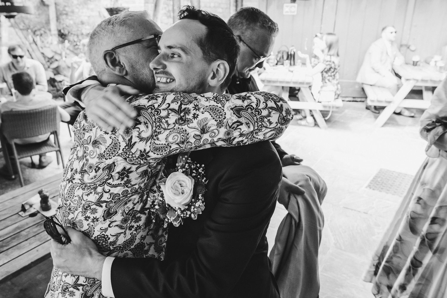 A black and white photo collage of candid moments from a wedding celebration with dancing and embraces.