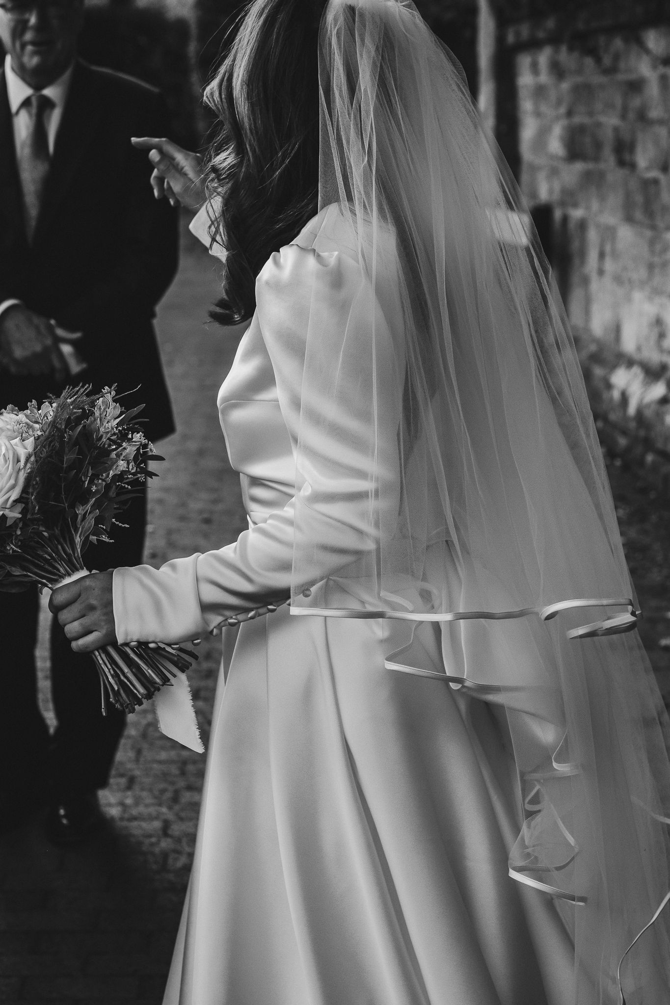 A black and white series of wedding photos showing the bride in a flowing white dress and veil from different angles.