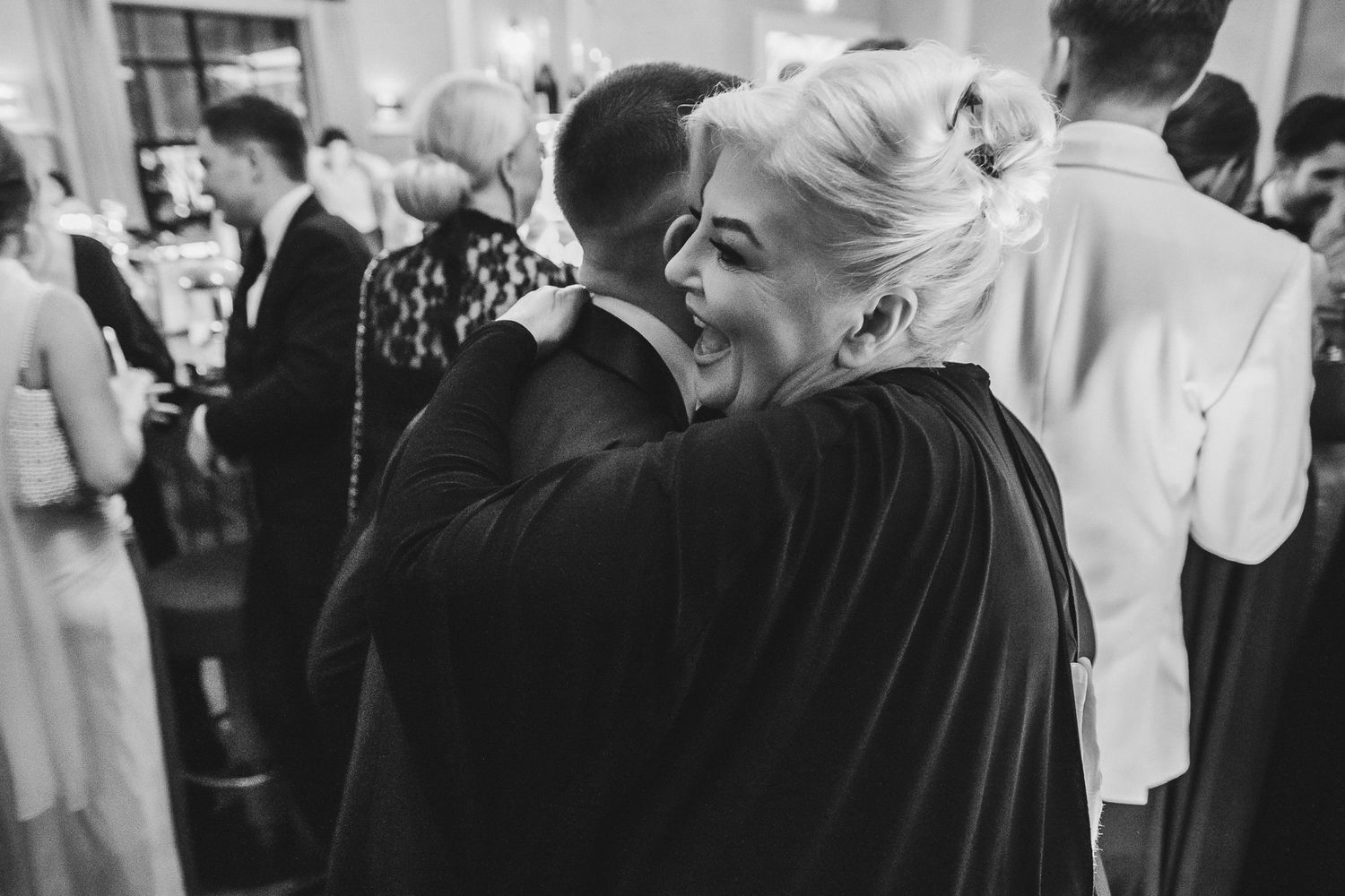 Wedding guests dance and celebrate on a crowded dance floor at an elegant reception venue.