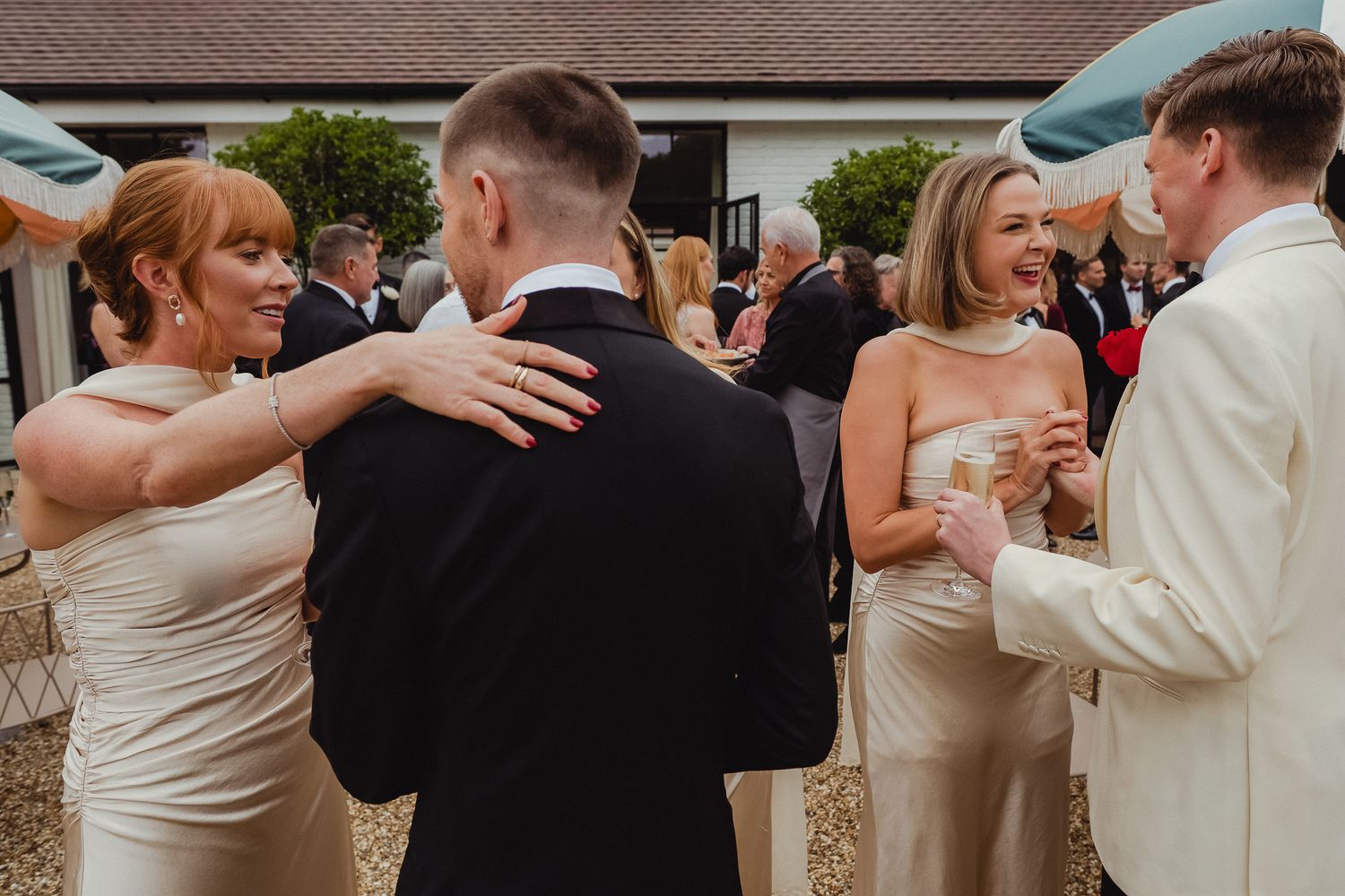 Wedding guests dance together in a line during a reception celebration on an outdoor patio.