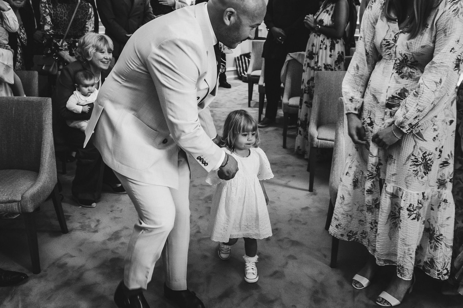 Wedding guests dancing and celebrating together at an outdoor reception party in formal attire.