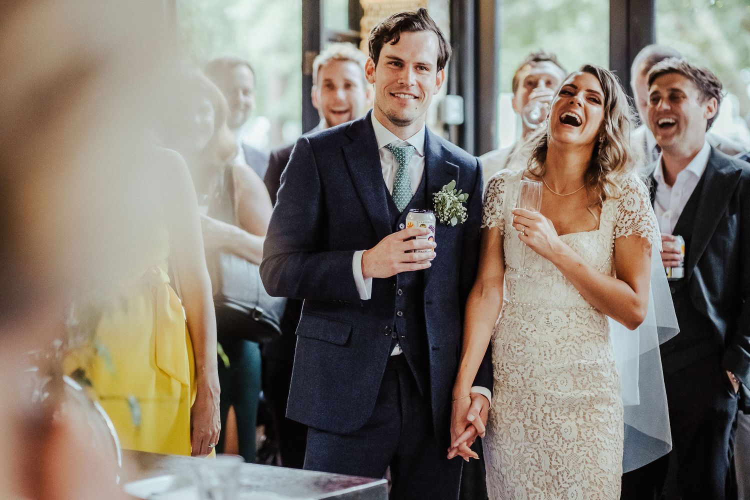 Wedding celebration candid moments showing joyful laughter and dancing at an indoor reception venue.