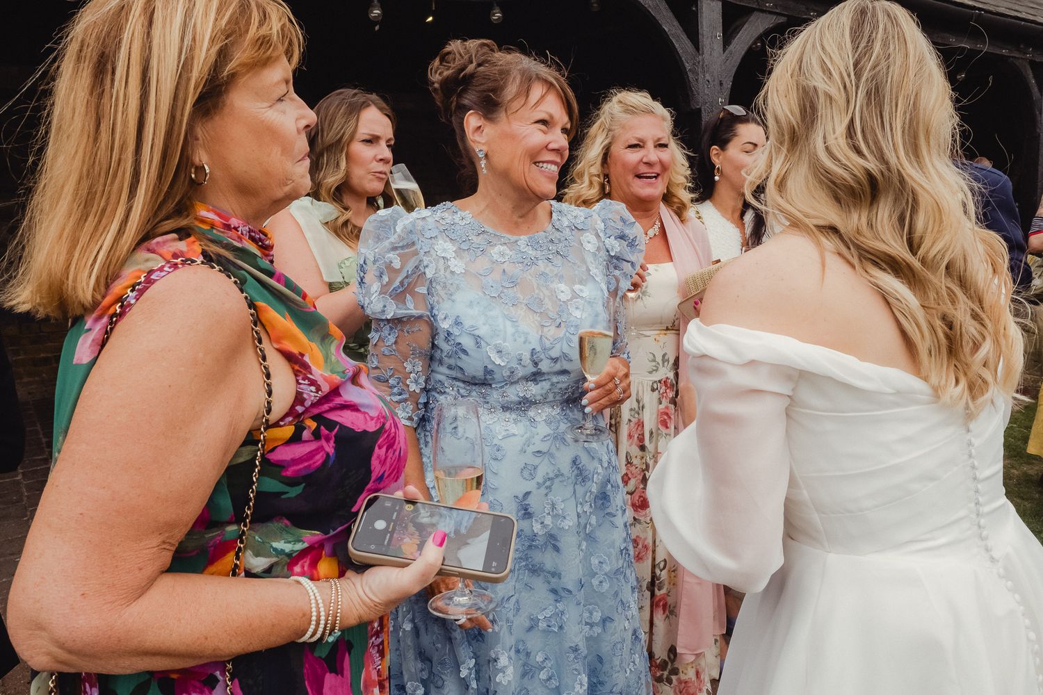 A group of wedding guests dancing and celebrating together at an outdoor reception party.