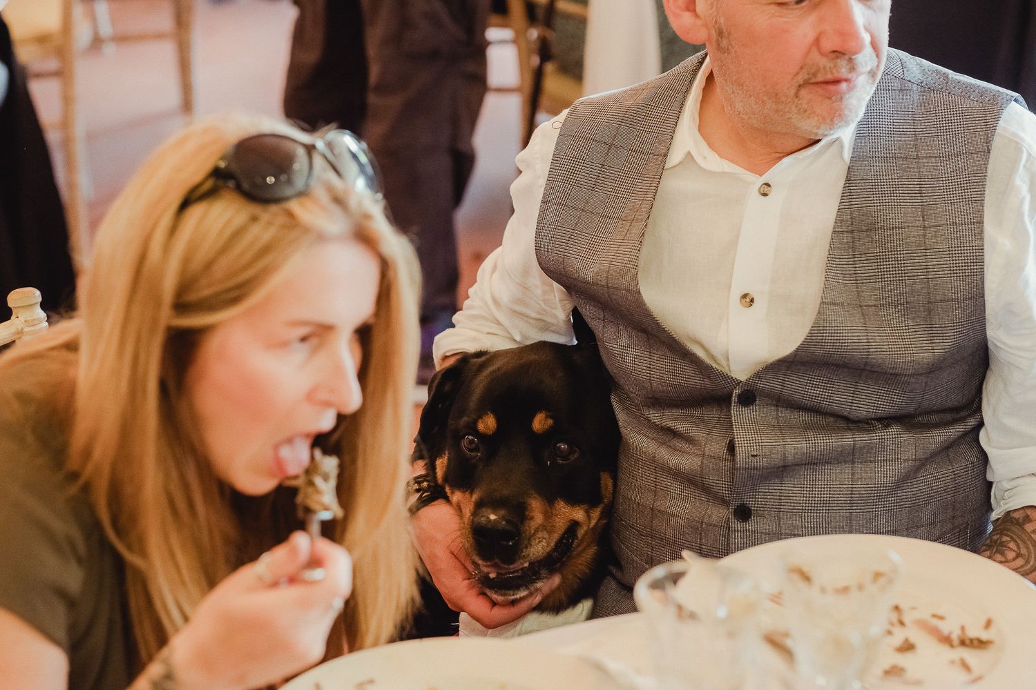 A happy couple and their dog share a joyful moment during a wedding celebration.