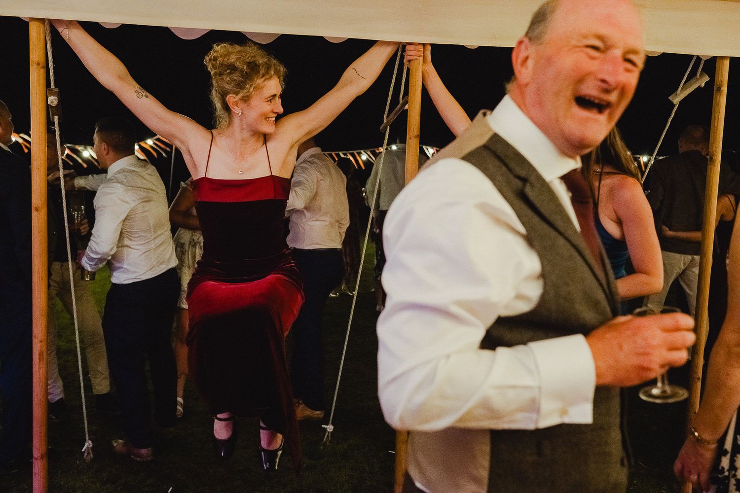 Wedding reception guests dance and celebrate together on a crowded dance floor at an evening party.
