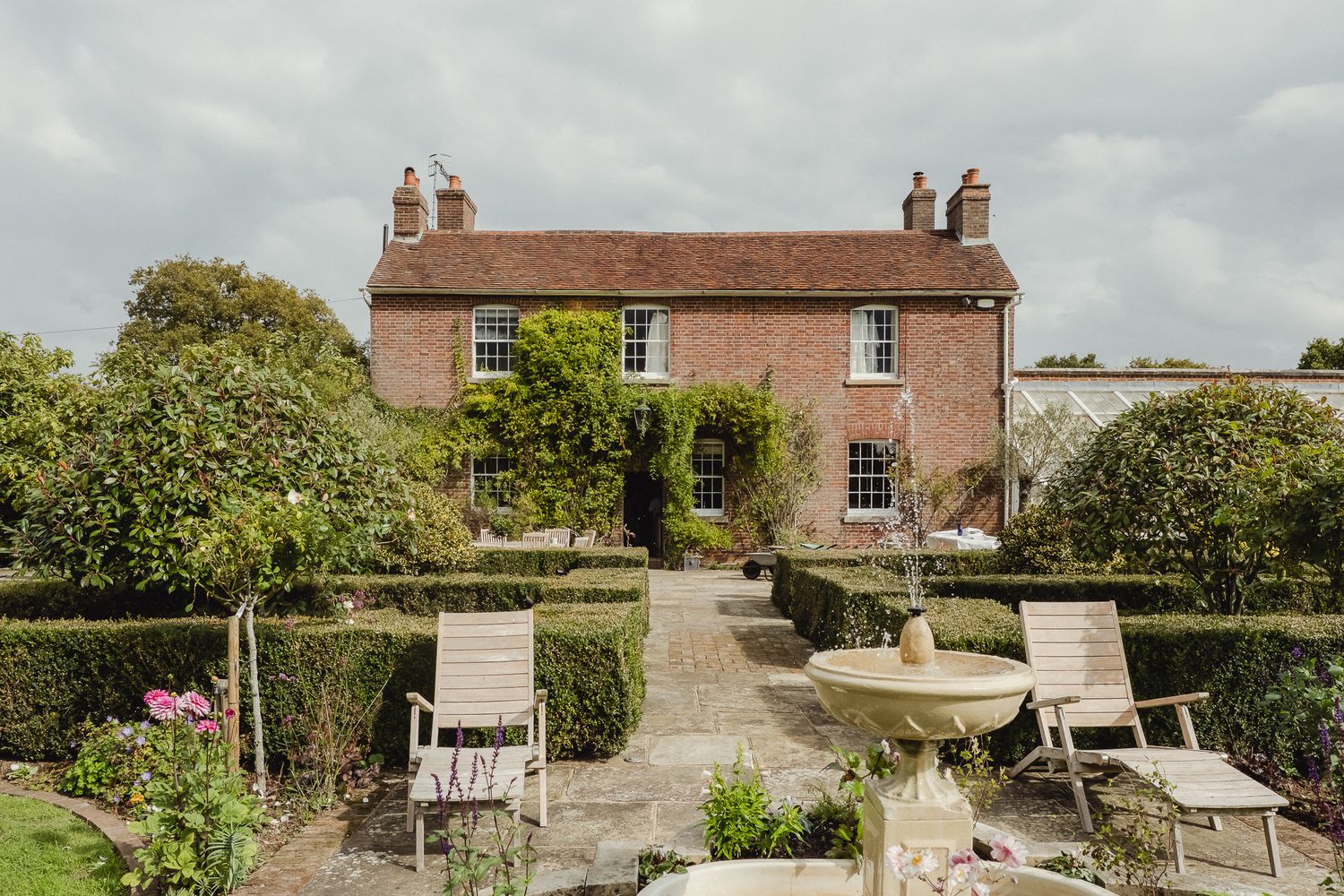 A series of garden views showing stone paths, outdoor furniture, and landscaped spaces at a rustic country estate.