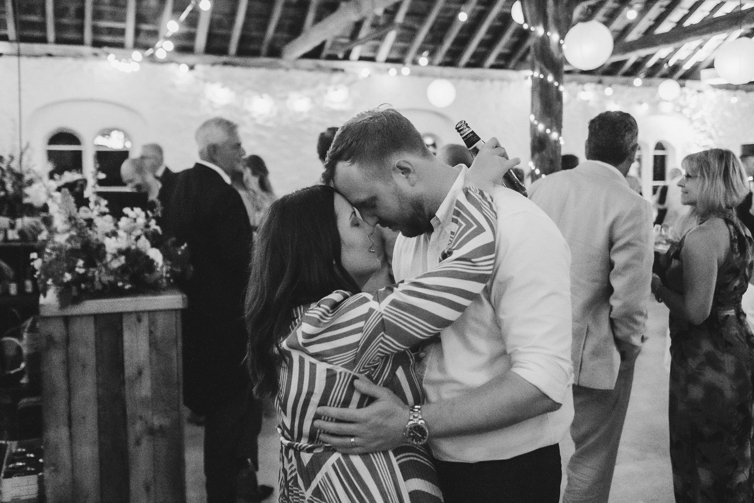 People dance together at a formal event in what appears to be a wedding reception or celebration.