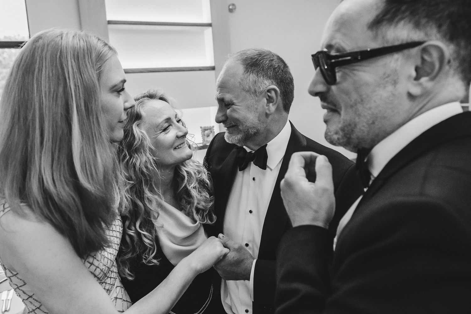 A series of candid black and white photographs showing people laughing and interacting at a formal event.